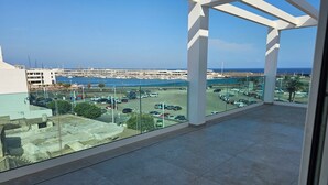 A balcony with a clear view of a marina and the sea.