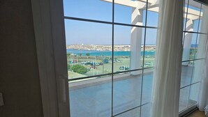 A room with a large window offering a view of a marina and boats.