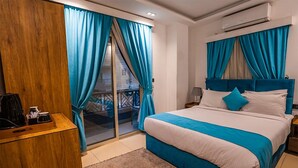 Ein Schlafzimmer mit Bett, Vorhängen, einem Holztisch und einer Klimaanlage.