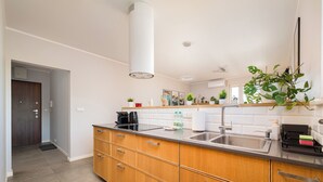 Une cuisine moderne avec des meubles en bois, un évier en acier inoxydable et un plan de travail noir.