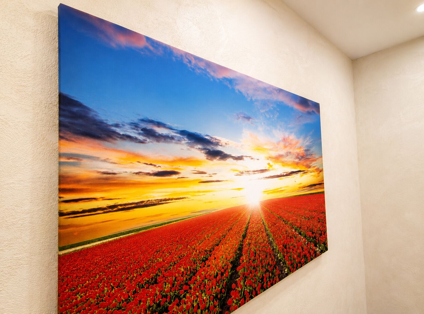 Una pintura grande de un atardecer sobre un campo de flores rojas.