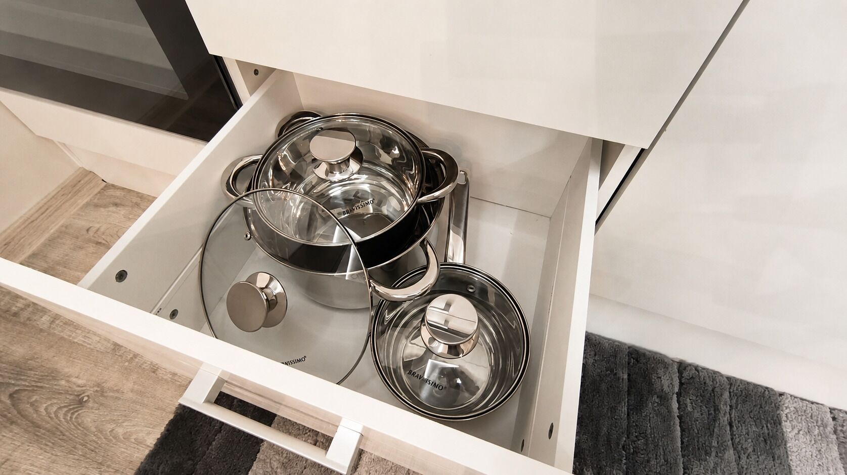 A drawer with stainless steel pots and pans.