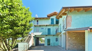 A multi-story building with a central staircase, balconies, and a brick wall. - Balcony in Pollenzo, just minutes from Alba and Bra (Pollenzo)
