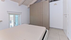 A bedroom with a bed, wardrobe, and a door with a lock. - Balcony in Pollenzo, just minutes from Alba and Bra (Pollenzo)