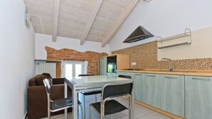 A compact kitchen with a dining table, chairs, and a built-in oven. - Balcony in Pollenzo, just minutes from Alba and Bra (Pollenzo)