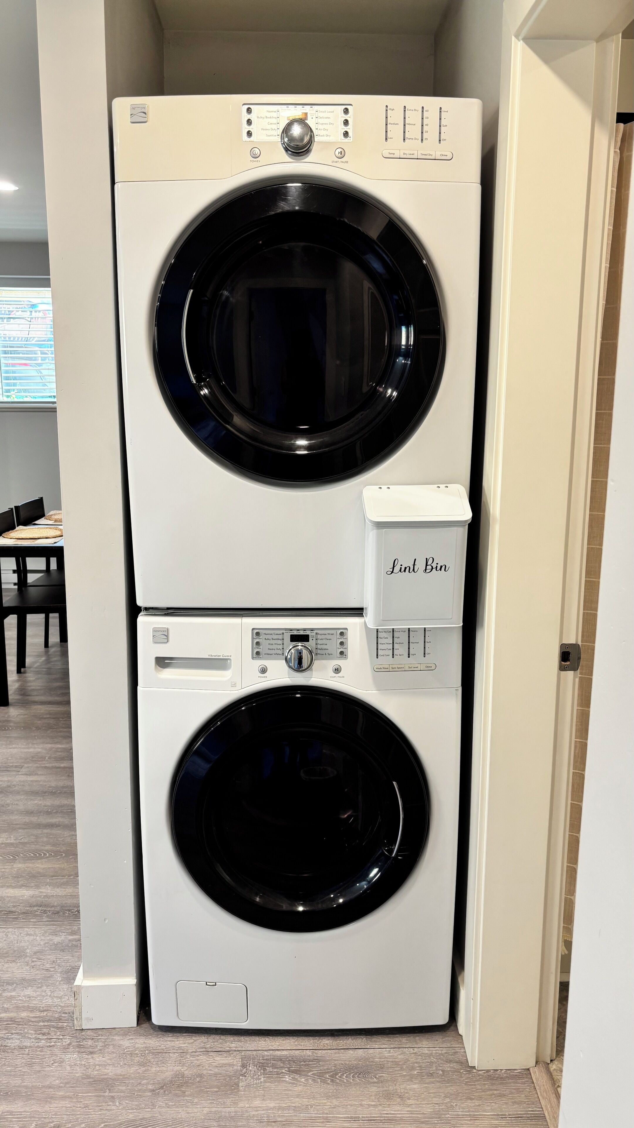 A stacked washer and dryer unit with a lint bin attached to the dryer.