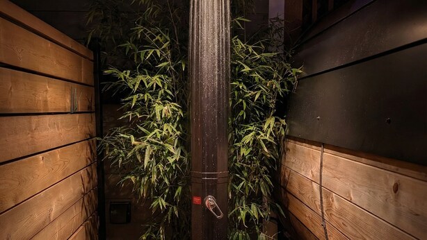 A vertical water feature in a wooden planter with a lock mechanism, surrounded by bamboo plants. - Private Sauna Retreat • EV Charger • Quiet Creekside Stay (Duncan)