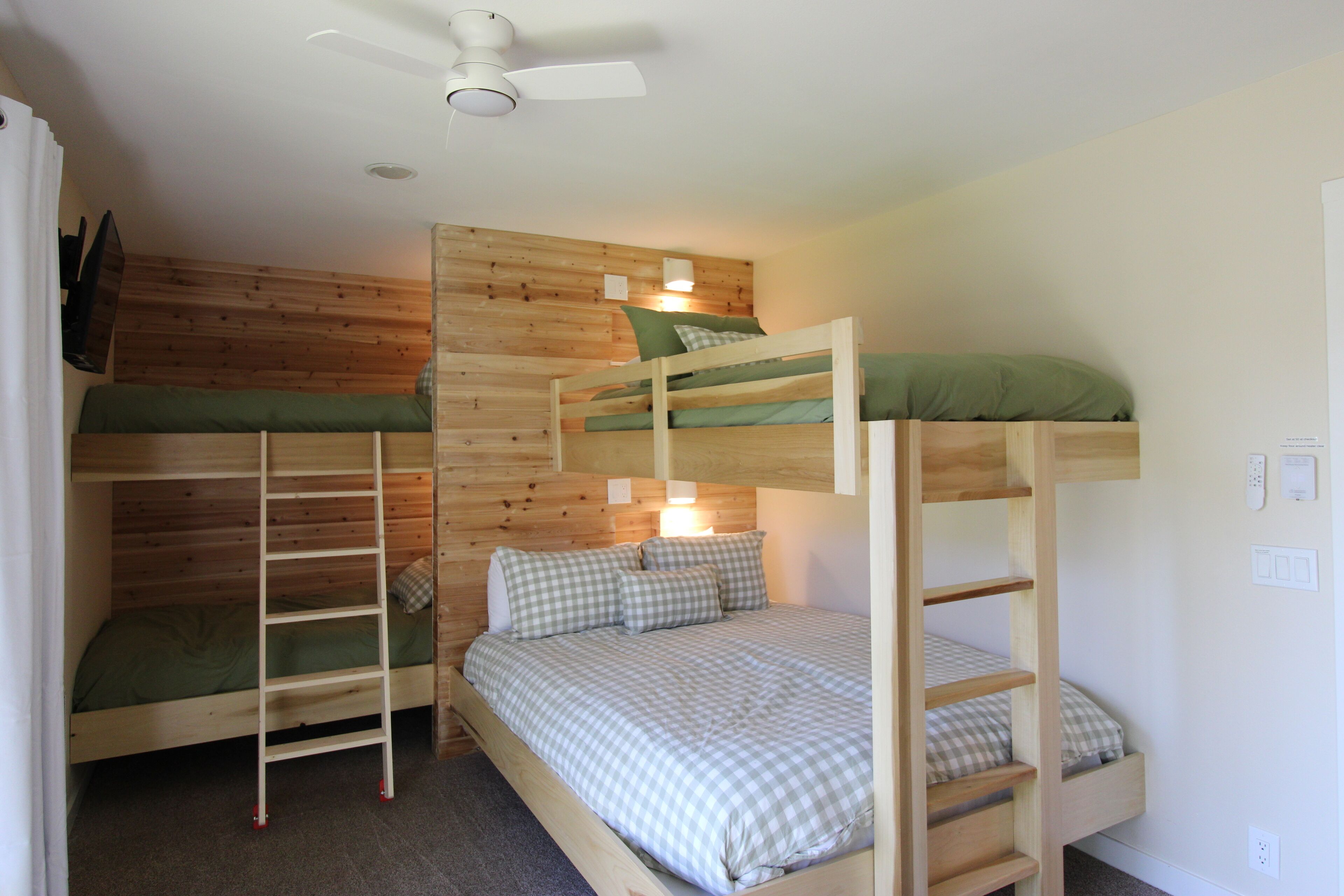 Dormitorio con literas, techo de madera y ventilador de techo.