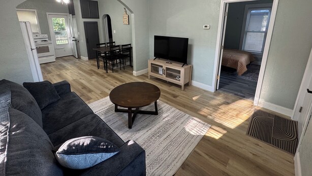 Un salon comprenant un canapé, une table basse, un téléviseur et un coin repas avec des chaises et une table.