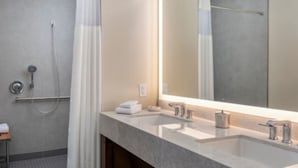 A modern bathroom with a large mirror, two sinks, and a shower. - Marriott Vacation Club, Waikiki (Studio) (Honolulu)