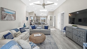 A spacious living room with a sofa set, a coffee table, and a television.
