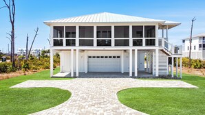 A two-story house with a garage, a covered porch, and a landscaped driveway.