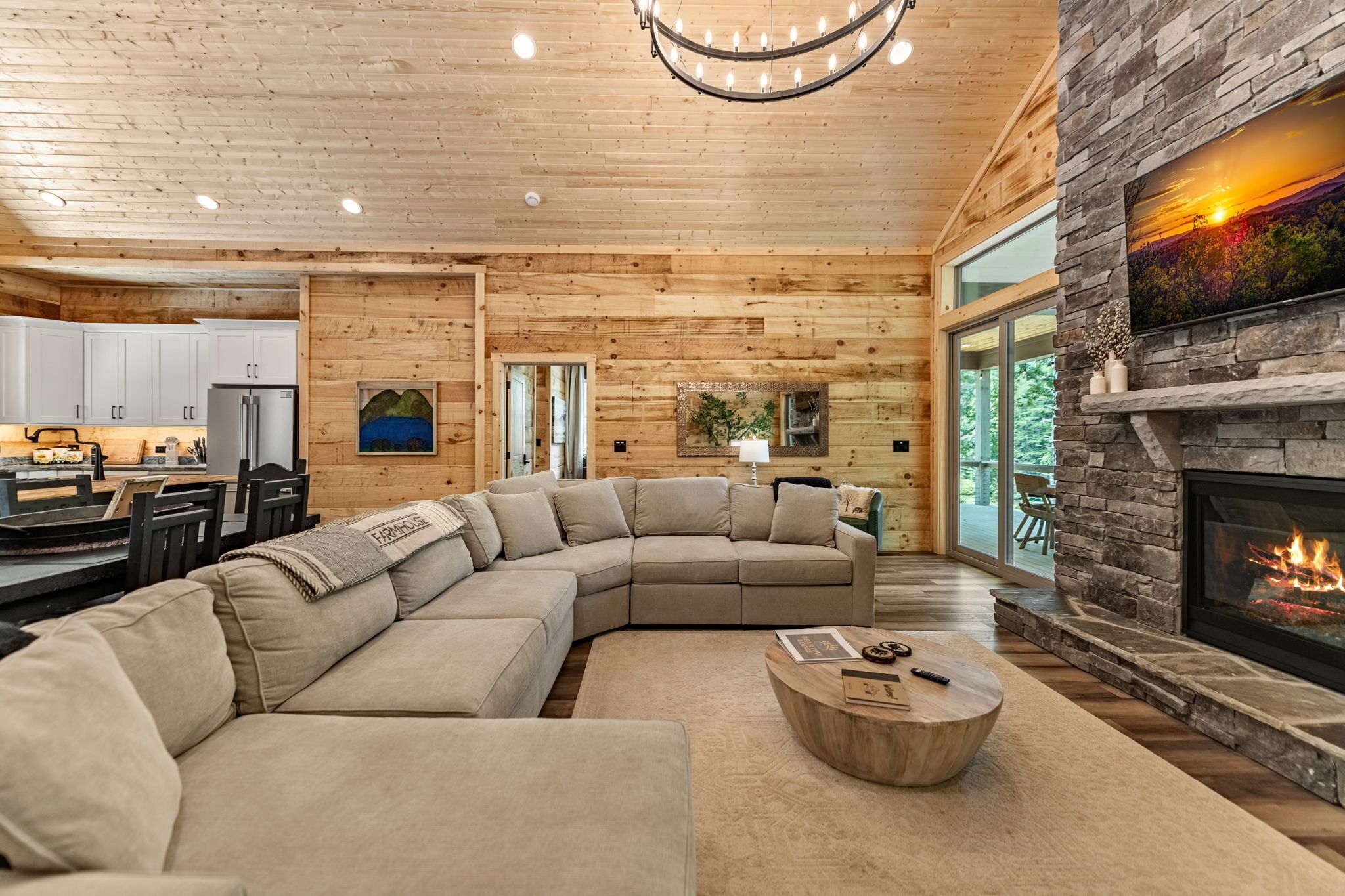 A spacious living room with a large sectional sofa, a fireplace, and a view of the outdoors.