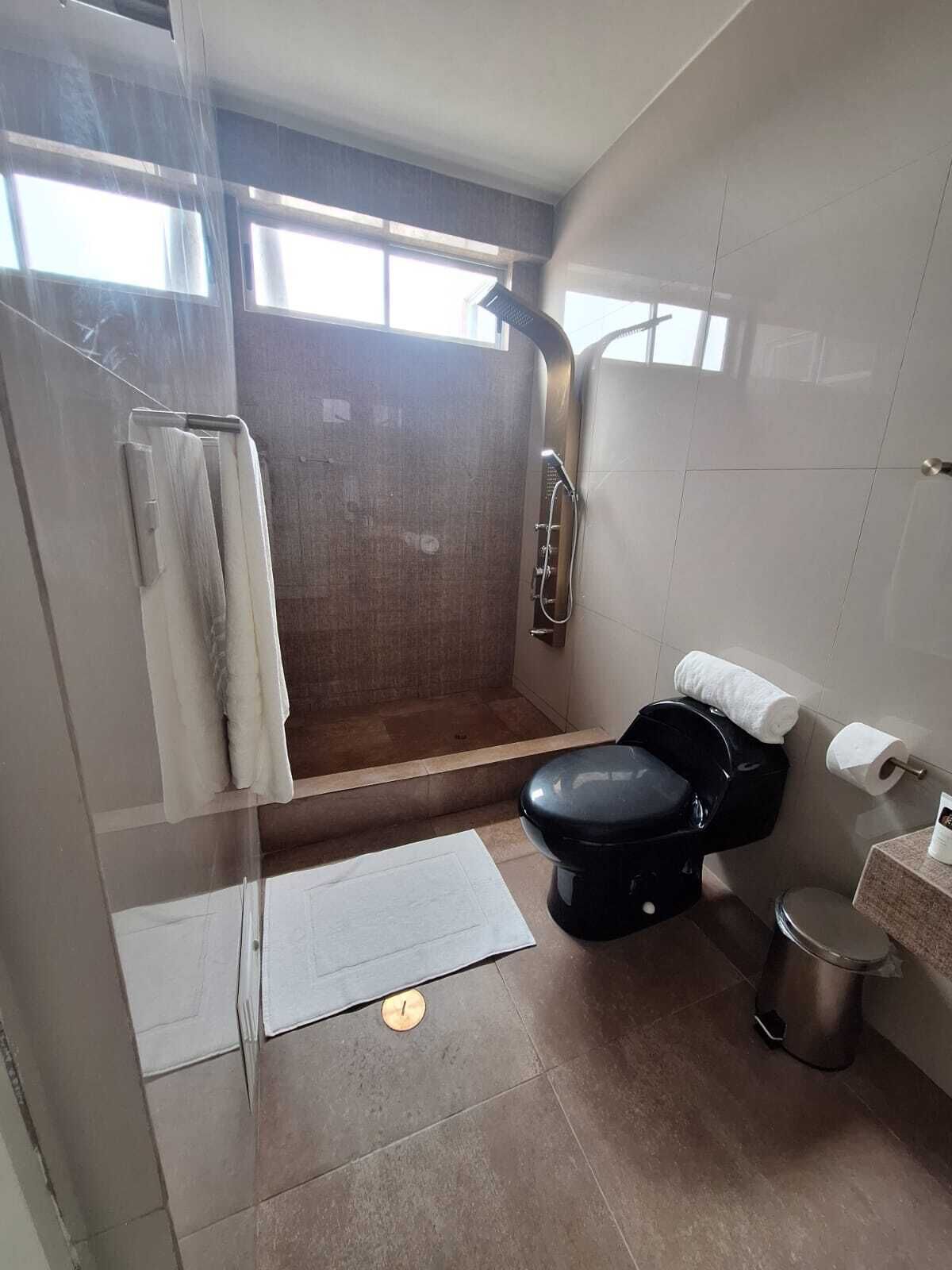 Un baño con ducha, inodoro y lavamanos.