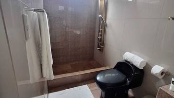 Un baño con ducha, inodoro y lavamanos.