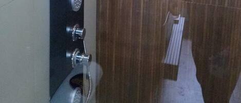 A bathroom with a shower area, a toilet, and a sink.