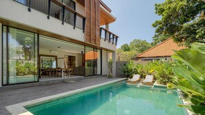 A modern two-story house with a swimming pool, outdoor seating, and lush greenery. - Villa Sunshine – Sparkling Style & Spacious Comfort in Sanur (Sanur)
