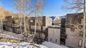 Un complesso moderno di edifici con diverse unità, una scala e un paesaggio innevato con montagne sullo sfondo.