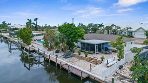 A waterfront property with a dock, a covered patio, and a swimming pool. - Garry's Landing! Canal front home with boat dock! (Bradenton)