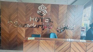 A reception desk with a herringbone wood pattern and a sign that reads "HOTEL Sandurga Gold". - Hotel Samdariya Gold - Rewa (Huzur)