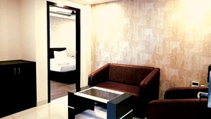 Una habitación moderna con sofá, una mesa de centro de vidrio, ventilador de techo y pared con textura.