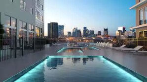 A rooftop pool with a cityscape view, surrounded by modern buildings.