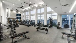 A modern gym with treadmills, weight machines, and dumbbells.