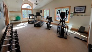 Ein Fitnessstudio mit Laufbändern, Crosstrainern und Kurzhanteln.