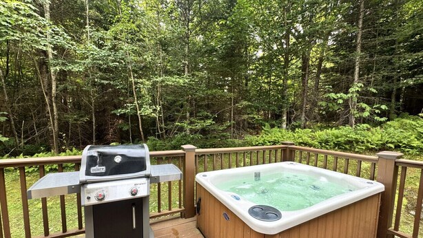Eine Terrasse mit Whirlpool und Grill.