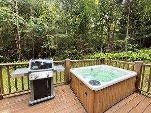 Eine Terrasse mit Whirlpool und Grill.