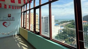 A room with large windows, a tiled floor, and a wall with a red and yellow flag decoration. - HOTEL SON THINH VUNG TAU (Ho Chi Minh City)