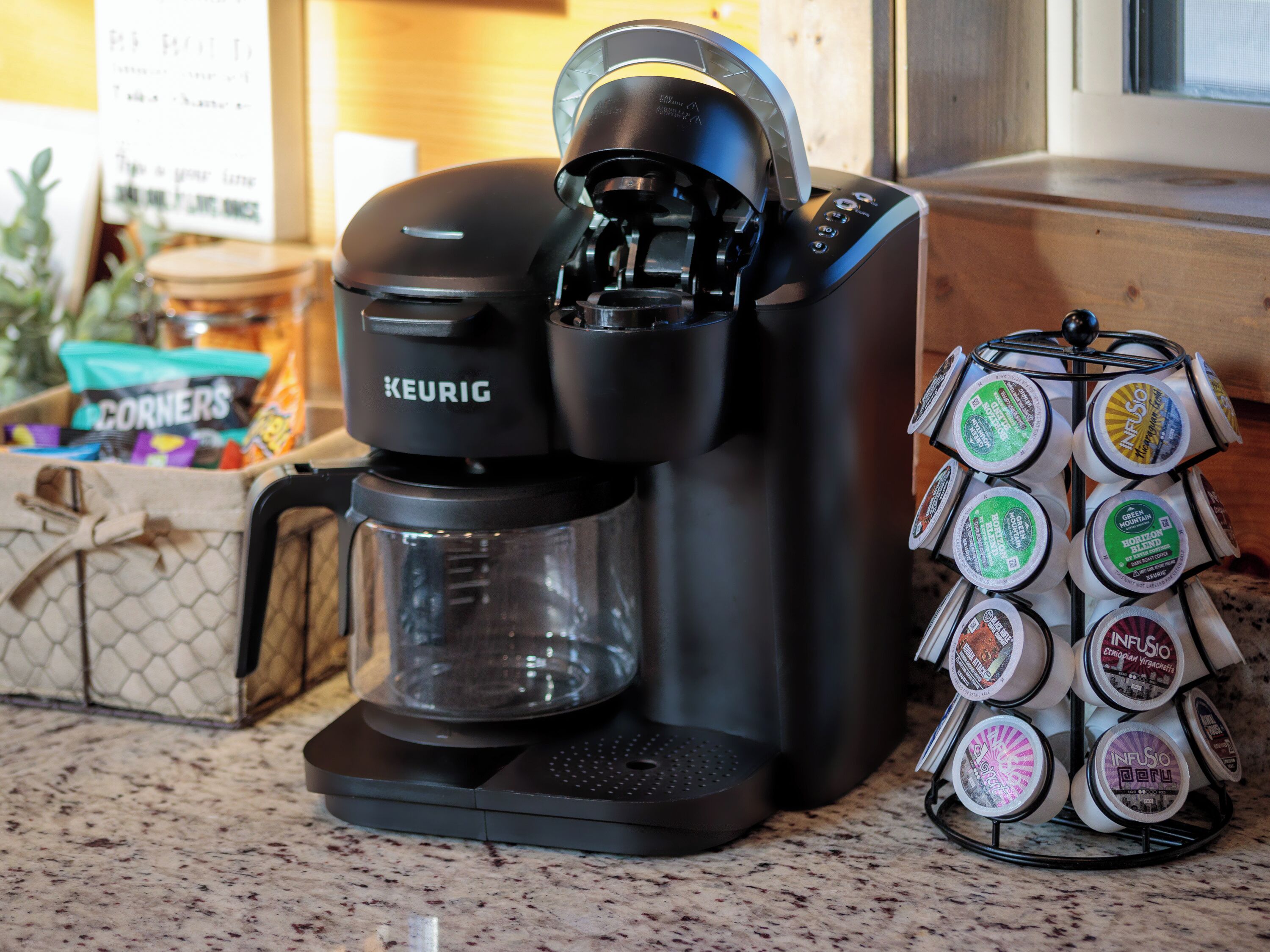 Una cafetera Keurig con un soporte para cápsulas de café a su lado.