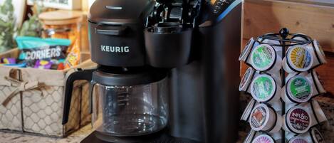 Una cafetera Keurig con un soporte para cápsulas de café a su lado.