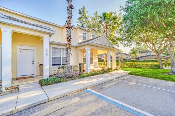 A residential house with a front porch, a mailbox, and a well-maintained lawn. - Charming 3-bedroom townhome near to attractions (Clermont)