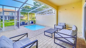 A covered outdoor area with a pool, seating, and a view of a residential neighborhood. - Charming 3-bedroom townhome near to attractions (Clermont)