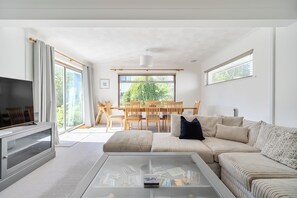 A modern living room with a sofa, coffee table, and a television. - Sleeps 9- KingBeds- FamilyFriendly- ContactlessCI (Wadebridge)