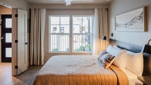 A bedroom with a bed, a ceiling fan, a large window, and a painting on the wall. - Gloria Inn 2 -5 minutes from Baylor and 2 Blocks to Magnolia (Waco)