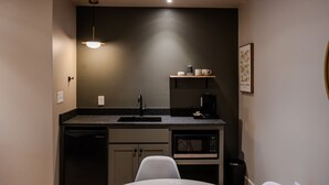 A compact kitchenette with a sink, microwave, and coffee maker. - Gloria Inn 2 -5 minutes from Baylor and 2 Blocks to Magnolia (Waco)