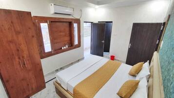 A bedroom with a bed, wooden wardrobe, and a window with a view.