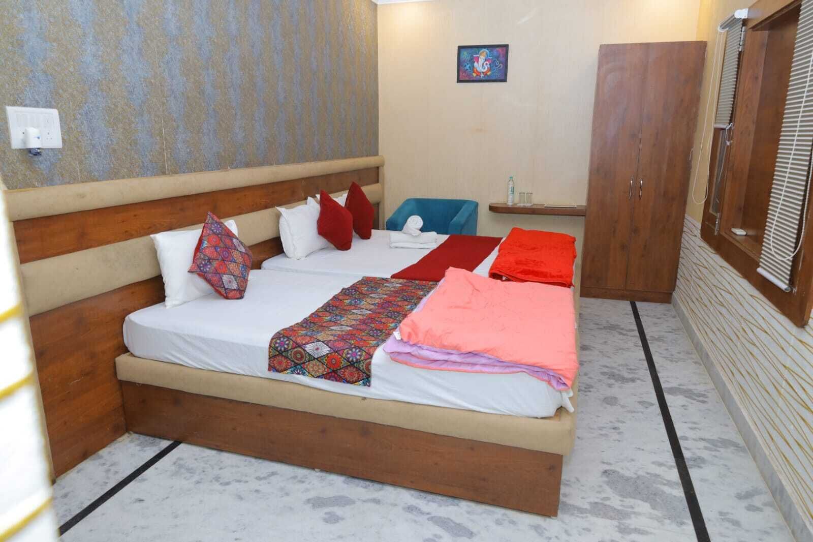 Habitación individual con una cama de madera, un edredón estampado y varias almohadas.
