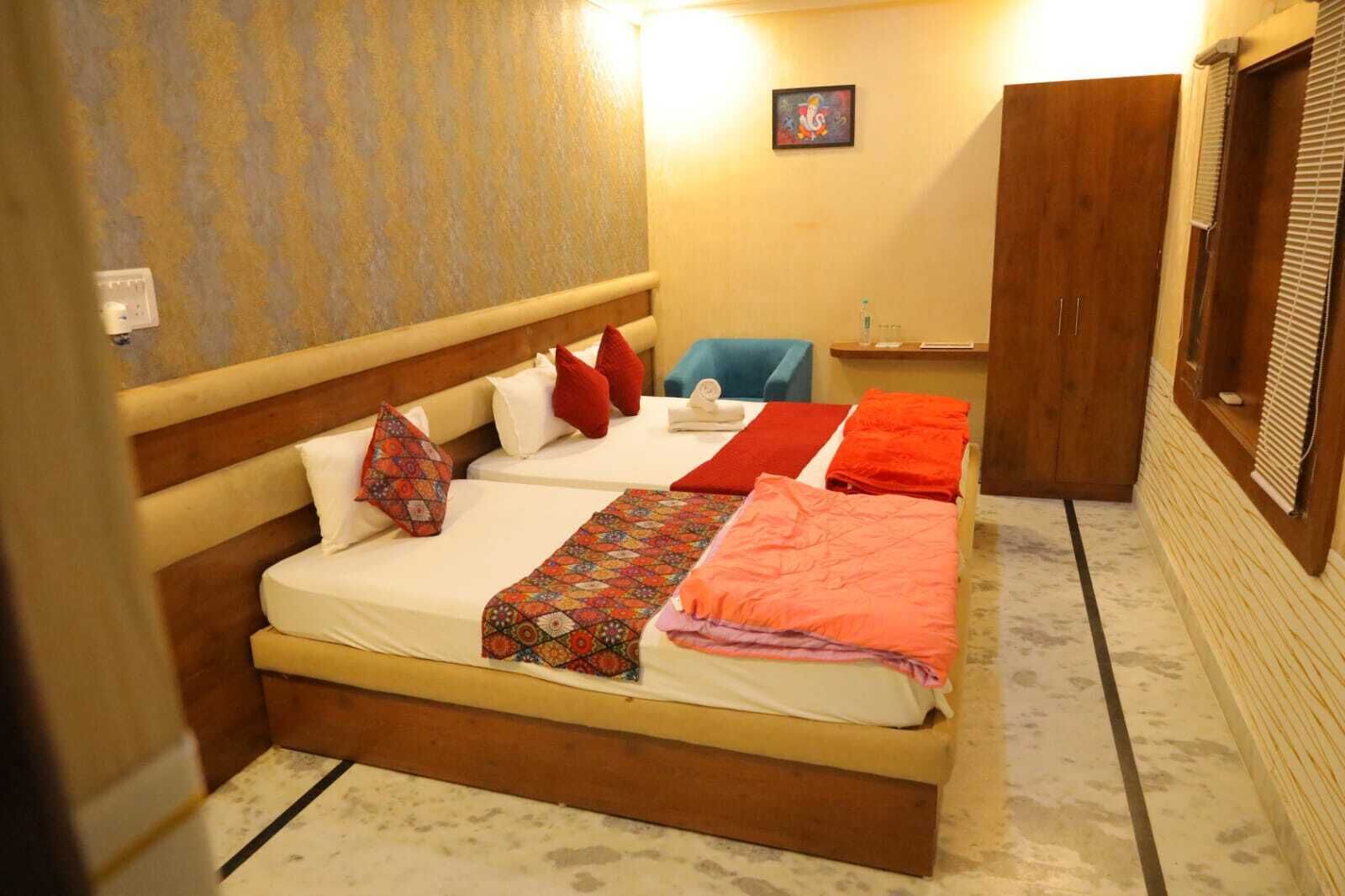 Una habitación de hotel con una cama grande, dos almohadas, una colcha y una mesita con una silla.