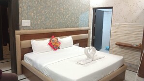 A neatly made bed with white linens, a wooden headboard, and a decorative pillow.