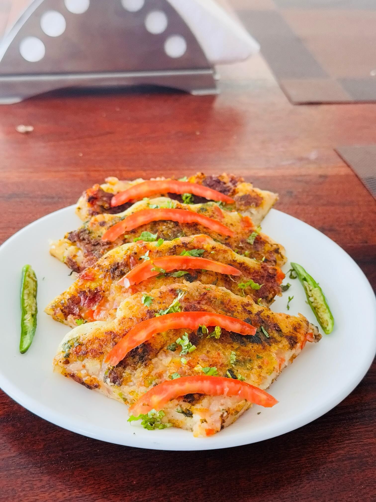 Prato de comida com fatias de carne, tomates e pimentões verdes sobre um prato branco.