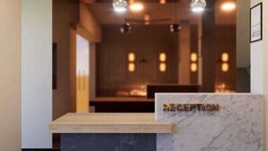 A reception area with a marble counter and a wooden desk.