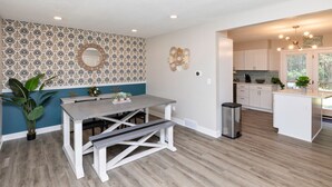 A modern kitchen with white cabinets, a grey countertop, and a hanging light fixture. - Modern Comfort in Des Moines` West Side 4BR/2.5BR (Clive)