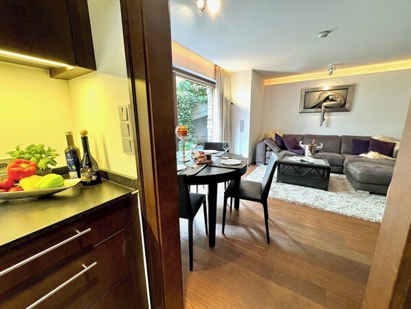 Un espacio abierto con zona de estar, una mesa de comedor y un cuadro en la pared.