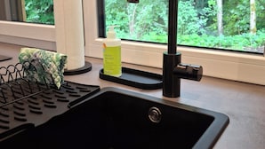 A kitchen sink with a modern faucet, a paper towel holder, and a soap dispenser on a window sill. - Allgäu vacation apartment 2 adults + 2 children Kempten-Rothkreuz in the countryside (Kempten (Allgäu))