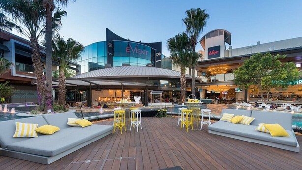A rooftop pool area with seating and a view of the Event building. - Modern 2BR Apartment Balcony & Central Convenience (Macgregor)