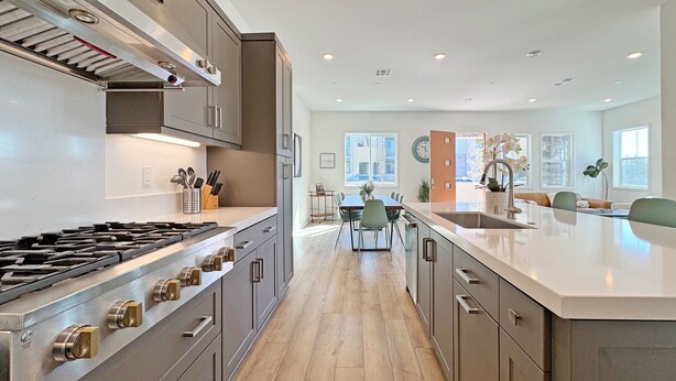 A modern kitchen with stainless steel appliances, a dining area with a large island, and a view of the city through the windows. - Fabulous 4-bedroom house with AC in irvine Lake Forest (Lake Forest)
