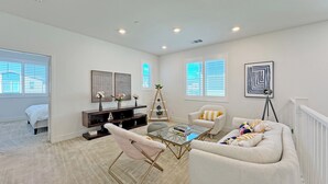 A spacious living room with a glass coffee table, white sofas, a wooden TV stand, and artwork on the walls. - Fabulous 4-bedroom house with AC in irvine Lake Forest (Lake Forest)